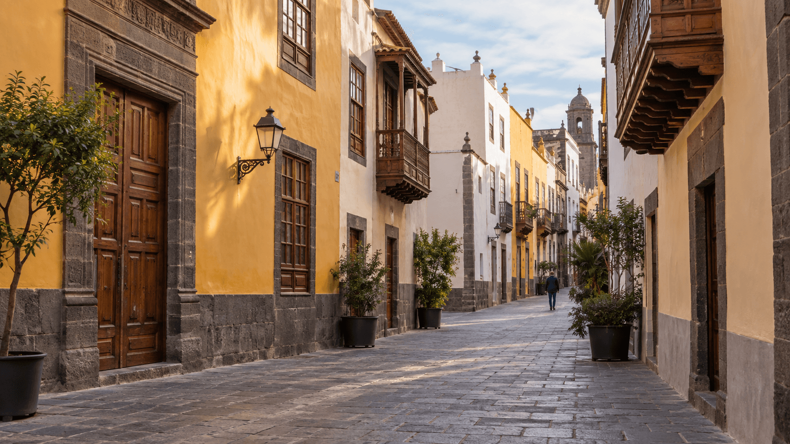 Illustration of a quiet historic street in Vegueta with pale façades and dark stone detailing.